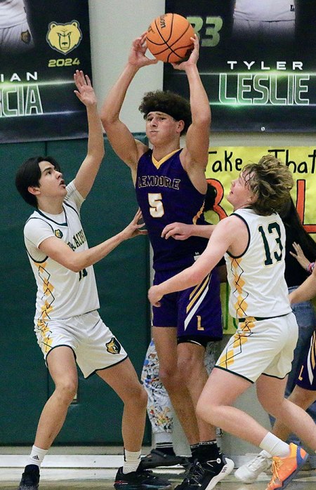 Lemoore's Andrew Mora looks to pass the ball between a pair of Sierra Pacific defenders in Tuesday's basketball game.